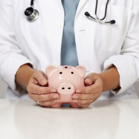 Doctor holding a piggy bank