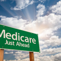 Medicare just ahead road sign over sky background