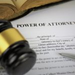 power of attorney document with gavel, pen and book