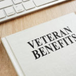 Handbook about Veteran Benefits on a desk surrounded by office supplies
