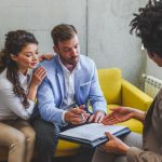 Young married couple signing real estate purchase contract  afte