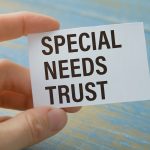 Businessman holding a card with SPECIAL NEEDS trust message