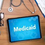 Medicaid Professional doctor use computer and medical equipment all around, desktop top view