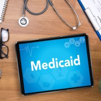 Medicaid Professional doctor use computer and medical equipment all around, desktop top view