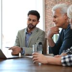 Male notary working with mature couple in office