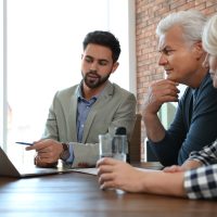 Male notary working with mature couple in office