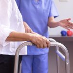 Nurse helping senior woman hand holding walker trying to walk,Care nursing home concept